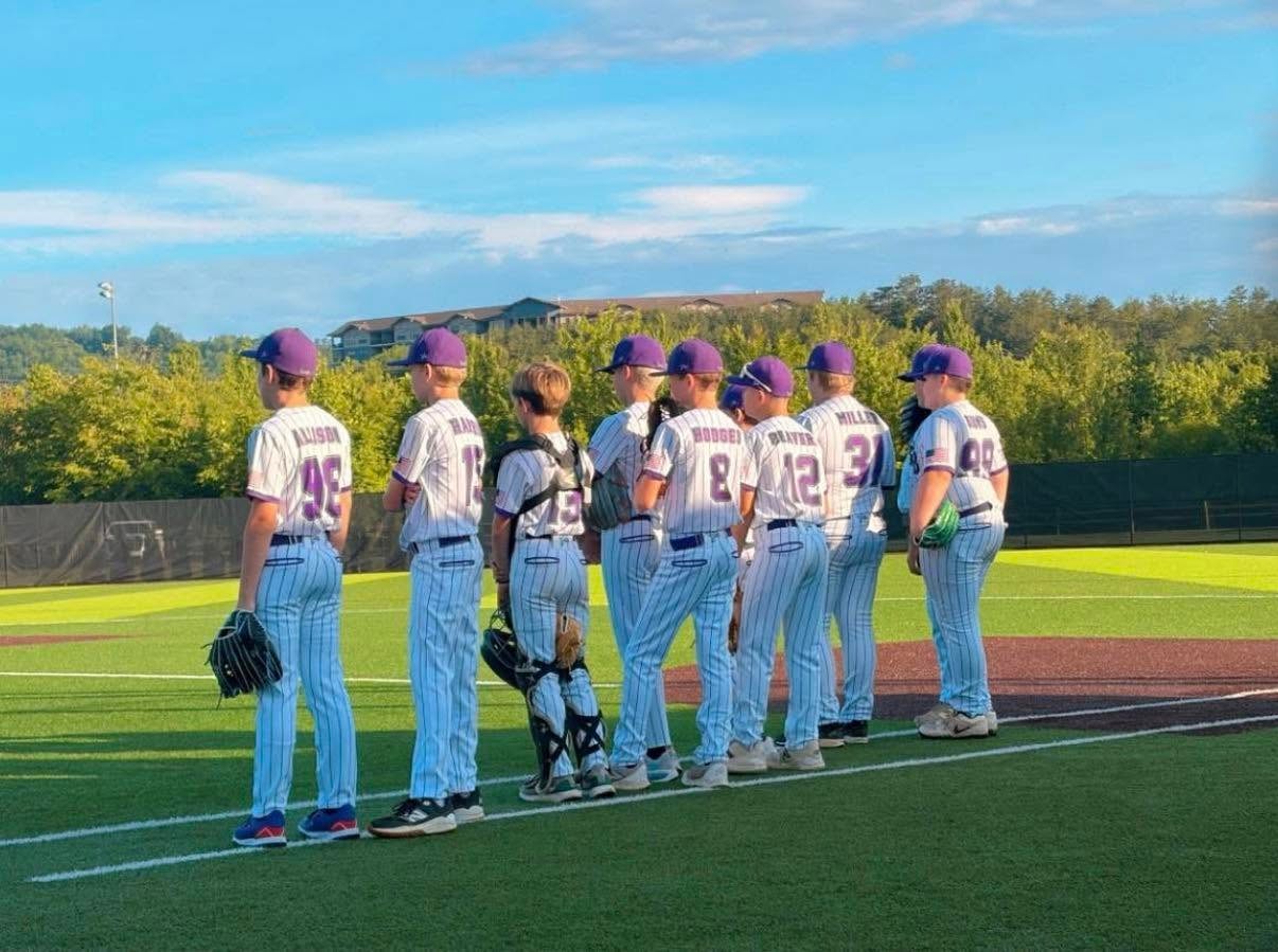 Dirtbags players lined up along the baseline in white pinstriped uniforms at sunset