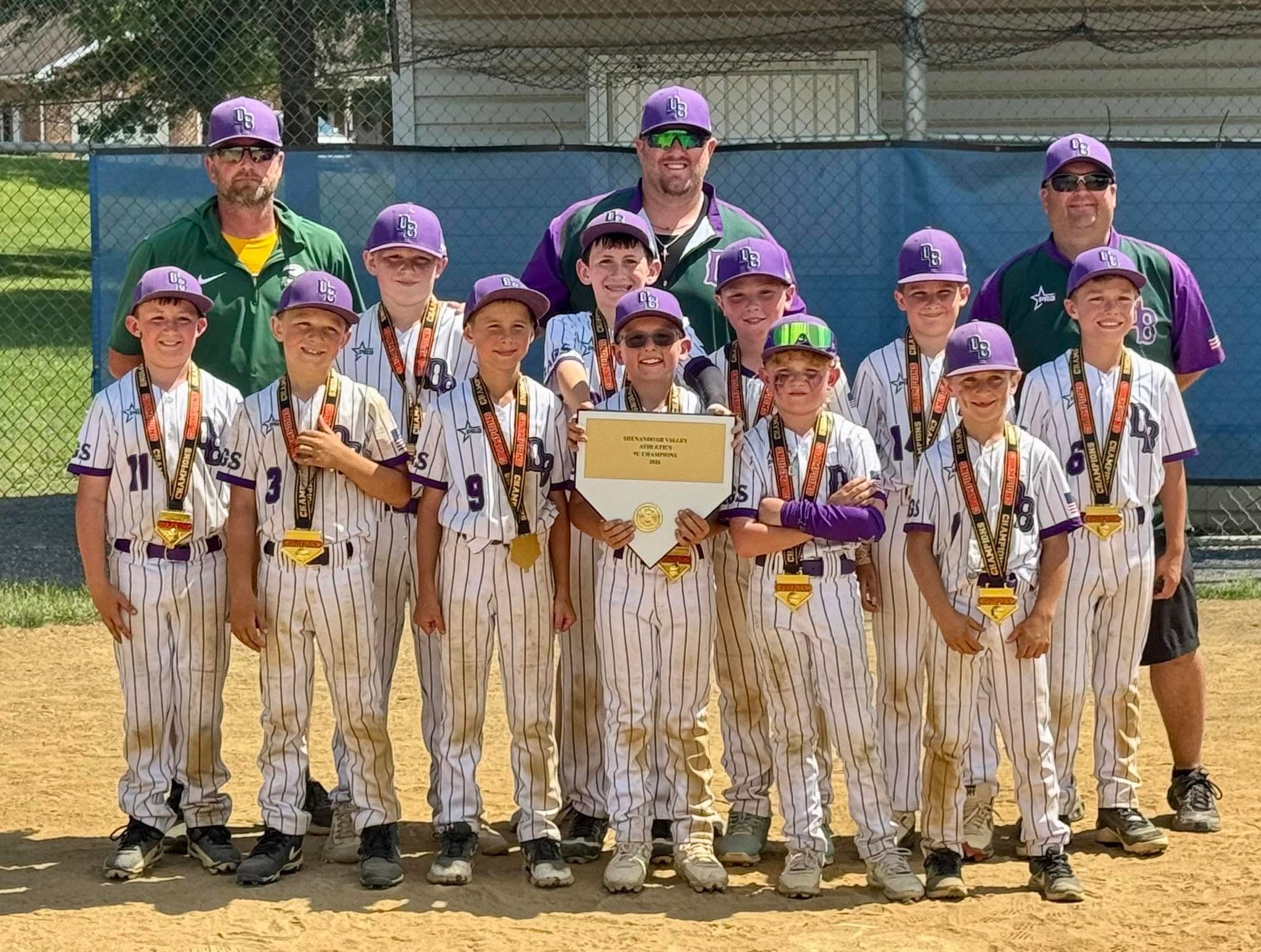 Dirtbags team and coaches posing with medals and a championship plaque after winning a tournament